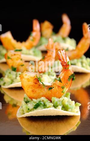 Collation de chips de remplissage avec de l'avocat et crevettes sautées aux herbes aromatisées. Banque D'Images