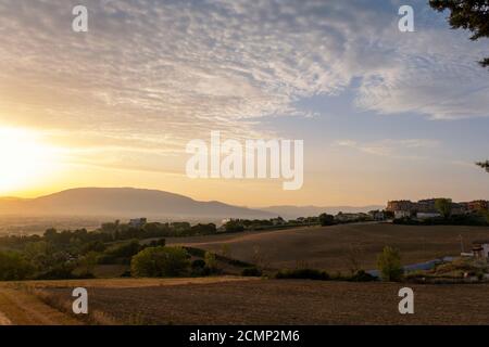 Toscane, paysage rural en Crète Senesi pays. Collines ondoyantes, ferme de campagne, cyprès des arbres, champ vert sur un coucher de soleil chaud. Sienne, Italie Banque D'Images