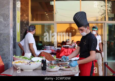 Un chef turc, installé dans un masque facial, prépare un plat à servir dans le restaurant de l''hôtel. Mesures de sécurité pour les touristes pendant le coronavirus Covid-19 Banque D'Images