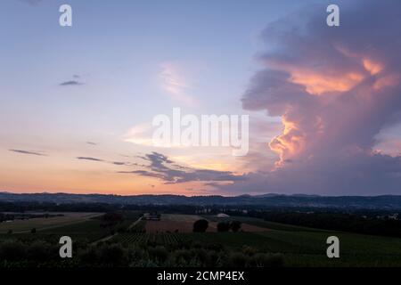 Toscane, paysage rural en Crète Senesi pays. Collines ondoyantes, ferme de campagne, cyprès des arbres, champ vert sur un coucher de soleil chaud. Sienne, Italie Banque D'Images