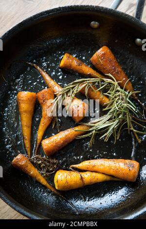 Carottes épicées au romarin dans une poêle Banque D'Images