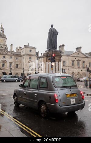 Un taxi londonien autorisé s'est arrêté au feu rouge en face de Horse Guards Parade, par une journée humide et rêveuse. Les taxis sont un moyen de transport populaire Banque D'Images