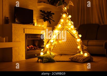 intérieur d'une salle de jeux pour enfants avec tente, lampes et jouets dans l'obscurité Banque D'Images