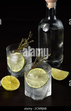 Gin Tonic avec une tranche de lime et branches de thym Banque D'Images