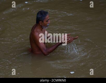 Les dévotés hindous indiens exécutent Tarpan, un rituel pour payer l'obéissance à ses ancêtres le dernier jour pour offrir des prières aux ancêtres appelés Pitri Tarpan. Dans la mythologie hindoue, ce jour est également appelé 'Mahalaya' et décrit comme le jour où les dieux ont créé la déesse armée Durga dix pour détruire le roi démon Asur qui a tracé pour chasser les dieux de leur royaume. La période de cinq jours d'adoration de Durga, est attribuée comme le destroyer du mal. Agartala, Tripura, Inde. Banque D'Images