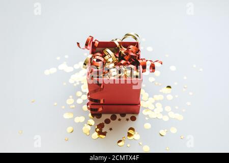 Ouvrez la boîte de fête avec des guirlandes et des confettis. Célébrer Noël ou le nouvel an ou gagner un prix, une promotion ou un autre concept de vacances. Banque D'Images