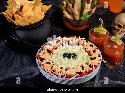 Effarante Halloween Seven Layer Taco DIP : transformez un apéritif classique en Halloween avec de l'olive noire Banque D'Images