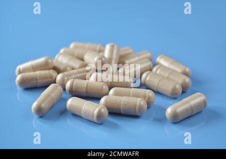 Heap Pills-capsules sur un fond bleu clair, gros plan. Faible profondeur de champ, mise au point sélective. Concept de soins de santé. Banque D'Images