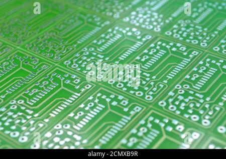 Vue rapprochée d'une carte électronique verte comme fond, mise au point sélective. Concept de développement de circuits électroniques Banque D'Images