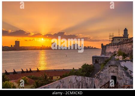 Magnifique coucher de soleil à la Havane avec vue sur la ville, le phare El Morro et le coucher de soleil sur les bâtiments - vue de l'autre côté de la baie Banque D'Images