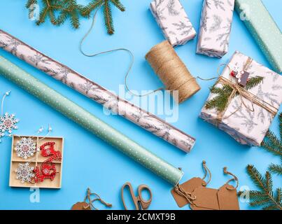 rouleaux de papier d'emballage, corde brune, ciseaux, décoration et une boîte carrée emballée avec un cadeau Banque D'Images