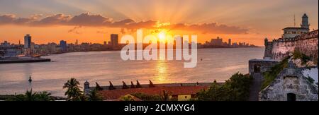 Magnifique coucher de soleil à la Havane avec vue sur la ville, le phare El Morro et le coucher de soleil sur les bâtiments - vue de l'autre côté de la baie Banque D'Images