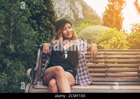 Jeune femme hippster assis dans le parc. Détendez-vous l'expression de la femme. Banque D'Images