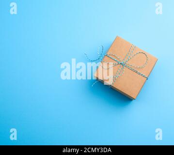 boîte carrée marron avec une corde à nouer sur un arrière-plan bleu Banque D'Images