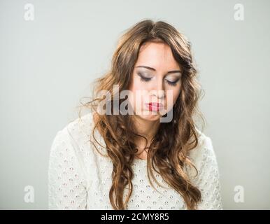 Portrait d'un jeune joli brunet avec un visage expressif ennuyé émotion sur fond gris Banque D'Images