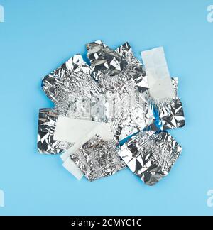 divers papier blanc froissé et papier d'aluminium ont utilisé des emballages de bonbons un arrière-plan bleu Banque D'Images