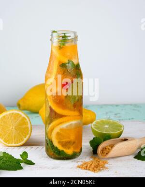 boisson rafraîchissante limonade avec citrons, canneberge, feuilles de menthe, citron vert dans une bouteille en verre Banque D'Images