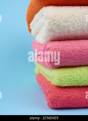pile de serviettes en tissu éponge de couleur pliée sur un bleu arrière-plan Banque D'Images