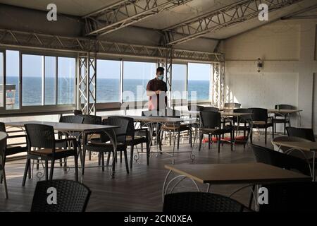 Gaza. 17 septembre 2020. Un travailleur palestinien est vu dans un café vide de la ville de Gaza, le 17 septembre 2020. Plus de 500 établissements touristiques, y compris des hôtels, des restaurants, des salles de mariage et des cafés, ont fermé leurs portes à Gaza après la décision du gouvernement d'enfermer le coronavirus, ce qui a conduit au chômage temporaire de plus de 7,000 travailleurs. Credit: Rizek Abdeljawad/Xinhua/Alamy Live News Banque D'Images