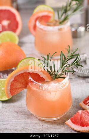 Cocktail rose Palomas citron vert et romarin frais combiné avec du jus de pamplemousse frais et de la tequila. Un technicien de maintenance Banque D'Images