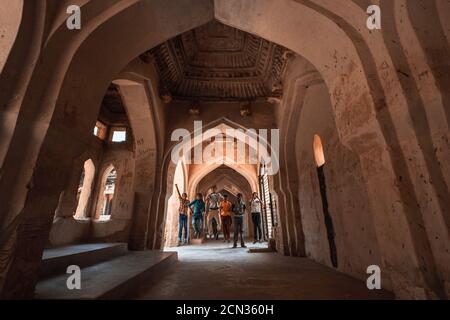 Les enfants sautant avec bonheur à l’intérieur de la salle de bains de la Reine à Hampi. C'est un bain colossal qui illustre l'excellence architecturale. Banque D'Images