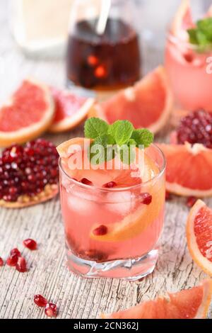 Cocktail Tequila avec grenade et jus de pamplemousse, teinté avec l'arôme d'une branche fraîche de mi Banque D'Images