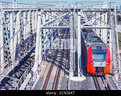 Le train à grande vitesse traverse le pont en approchant de la plate-forme de la gare. Banque D'Images