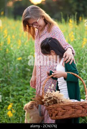 Mère et fille avec chiot dans le champ rural Banque D'Images