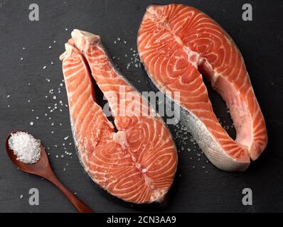 deux steaks de saumon cru au sel blanc sur un noir arrière-plan Banque D'Images