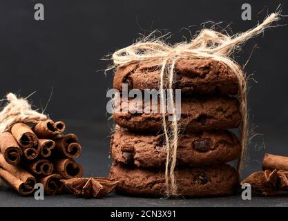 pile de biscuits ronds aux pépites de chocolat noués avec une corde sur un tableau noir Banque D'Images