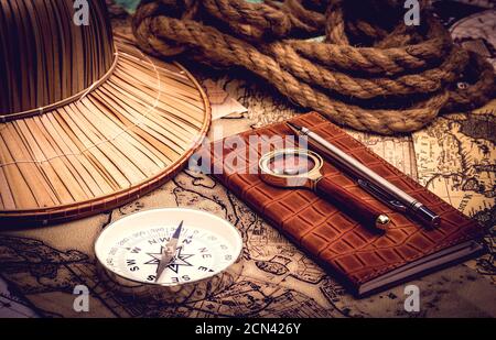 inspection nocturne d'une ancienne carte avec boussole et une loupe à la lumière d'une lampe Banque D'Images