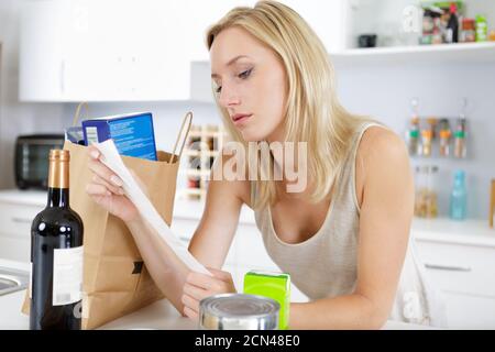 jeune femme au foyer avec livre de recettes dans la cuisine Banque D'Images