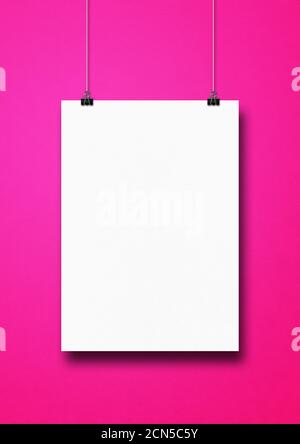 Affiche blanche suspendue sur un mur rose avec des pinces Banque D'Images