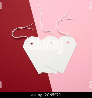 trois étiquettes rectangulaires de papier blanc sur une corde sur un arrière-plan coloré Banque D'Images