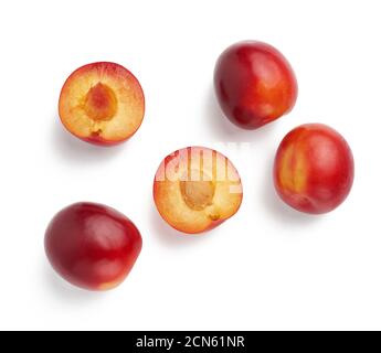 rouge mûr entier et moitiés de prune isolées sur blanc arrière-plan Banque D'Images
