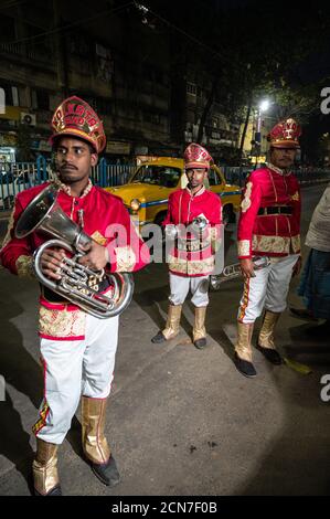 Trois musiciens indiens de groupe de mariage pratiquant leur routine musicale quotidienne en soirée sur la route à Kolkata, Inde. Banque D'Images