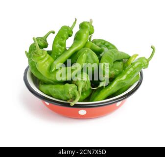 gousses de piment vert dans une plaque métallique rouge isolée sur arrière-plan blanc Banque D'Images