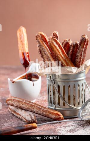 Bâtonnets de churros traditionnels à la cannelle et au chocolat. Banque D'Images