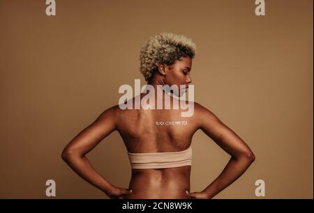 Femme militante avec des mots les vies noires sont peintes sur le dos. Femme afro-américaine protestant contre le racisme. Banque D'Images