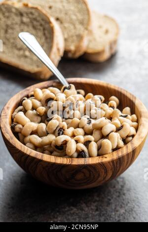 Grains de café à yeux noirs marinés dans un bol en bois. Banque D'Images