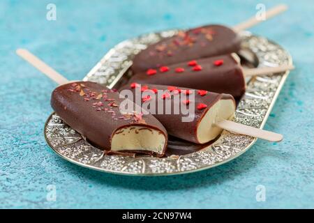 Crème glacée maison sur un bâtonnet de glaçage au chocolat noir. Banque D'Images