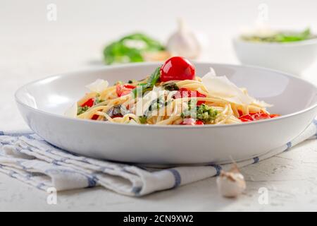 Pâtes italiennes avec sauce pesto, basilic frais et tomates cerises. Banque D'Images