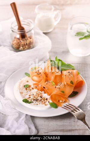 Salade végétarienne sans gluten avec carottes et yaourt assaisonnés de noix écrasées et d'épices, fonte de menthe Banque D'Images