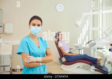 Médecin dentiste debout et regardant la caméra dans la clinique dentaire pendant l'examen Banque D'Images