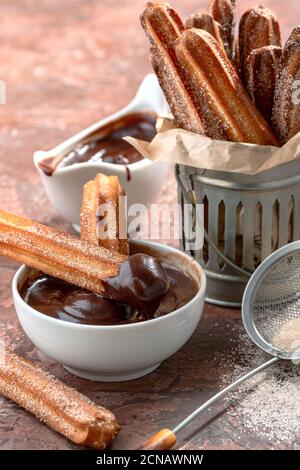 Bâtonnets de churros traditionnels à la cannelle et au chocolat. Banque D'Images