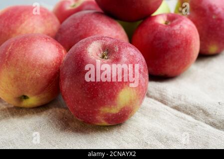 le bouquet de pommes mûres rouges repose sur un lin gris serviette de table Banque D'Images