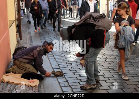 Prague, République tchèque, 12 octobre 2019. Une fille regarde un gars en train de discuter avec un mendiant. Le migrant engendra dans la rue d'une ville européenne. Banque D'Images