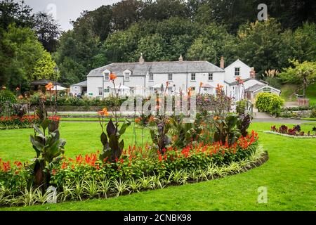 Les cottages Cornish du patrimoine de la Trenance surplombent d'agréables massifs fleuris dans les jardins paysagés de Trenance à Newquay, en Cornouailles. Banque D'Images