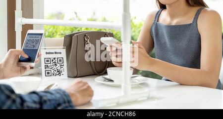 Client Panorama Asian scannant le code QR pour le menu en ligne un nouveau restaurant normal Banque D'Images