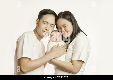 La famille asiatique heureuse de mère père et de bébé fils dans le studio de tournage portrait embrasser ensemble sourire avec les yeux fermés. La famille et la famille Banque D'Images